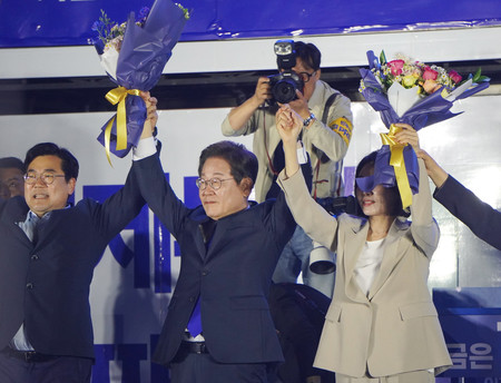 4日未明、ソウルの韓国国会前で支持者にあいさつする革新系政党「共に民主党」の李在明氏(中央)