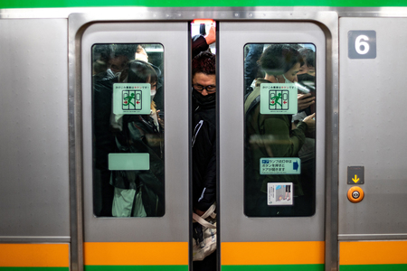 東京の新橋駅で電車に乗り込む通勤客ら（資料・ＡＦＰ時事）