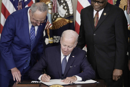 文書に署名する米国のバイデン前大統領(中央)=2022年8月、ワシントン(AFP時事)