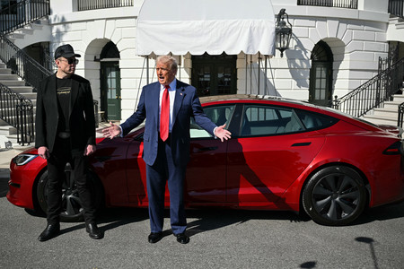 米電気自動車大手テスラの車の前で取材に応じるトランプ米大統領(右)と同社のイーロン・マスク最高経営責任者(CEO)=3月11日、ワシントン(AFP時事)