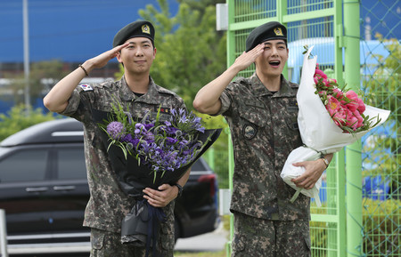 １０日、韓国江原道春川市で、兵役を終えてファンの前に姿を見せた「ＢＴＳ」メンバーのＲＭさん（左）とＶさん（ＥＰＡ時事）