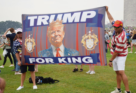 14日、ワシントンで行われた軍事パレードで、「トランプを王に」の旗を掲げたトランプ米大統領の支持者