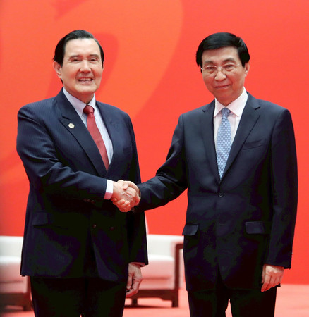 15日、中国福建省アモイで、共産党序列4位の王滬寧・全国政治協商会議主席(右)と握手する台湾の馬英九元総統(馬英九事務所提供・時事)
