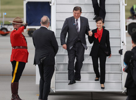 カルガリー国際空港に到着した石破茂首相(右から2人目)と佳子夫人(右)=15日午後、カナダ・カルガリー