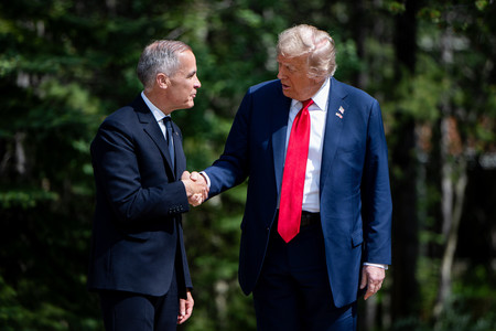 トランプ米大統領(右)と握手を交わすカナダのカーニー首相=16日、カナダ西部カナナスキス(EPA時事)