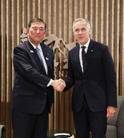 首脳会談を前に握手する石破茂首相(左)とカナダのカーニー首相=16日、カナダ・カナナスキス(代表撮影・時事)