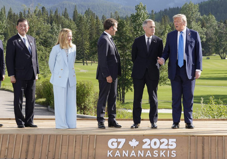 G7サミットの記念撮影で、記者の質問に答えるトランプ米大統領(右端)。左端は石破茂首相=16日、カナダ・カナナスキス(代表撮影・時事)