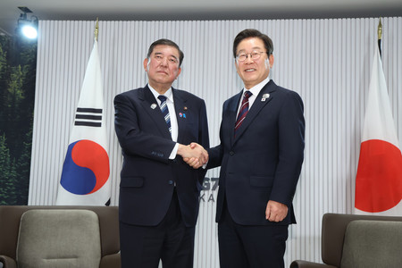 首脳会談を前に握手する石破茂首相(左)と韓国の李在明大統領=17日、カナダ・カナナスキス