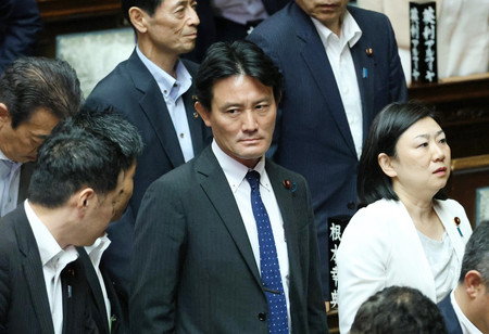 衆院本会議で解任決議案が可決され、厳しい表情を見せる自民党の井林辰憲・衆院財務金融委員長(中央)=18日午後、国会内