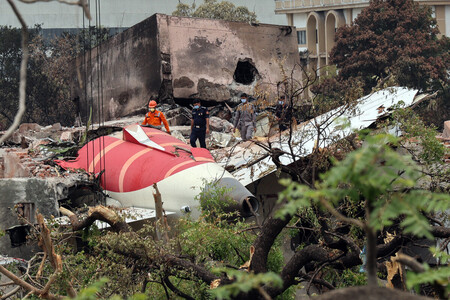 墜落した旅客機の残骸を調べる当局者＝１４日、インド西部アーメダバード（ＥＰＡ時事）