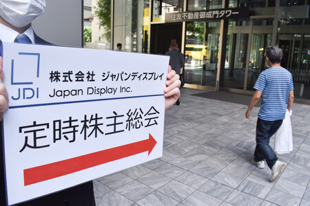 ジャパンディスプレイ(JDI)の定時株主総会に向かう人たち=21日午前、東京都港区