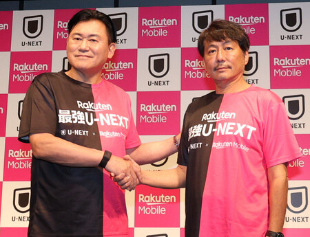 楽天モバイルの新サービス発表会で握手する三木谷浩史会長(左)とU―NEXTの宇野康秀会長=23日午後、東京都渋谷区