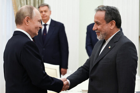 23日、モスクワのクレムリン(ロシア大統領府)で握手するプーチン大統領(左)とイランのアラグチ外相(AFP時事)