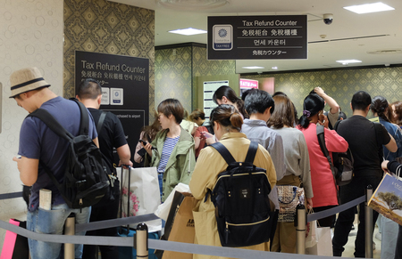 百貨店の免税カウンターに並ぶ訪日外国人旅行者ら=2018年4月、大阪市中央区