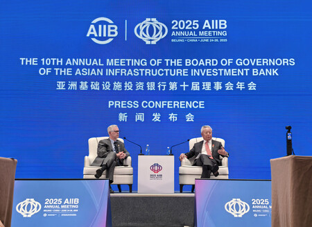 年次総会に合わせて記者会見するアジアインフラ投資銀行(AIIB)の金立群総裁(右)=26日、北京
