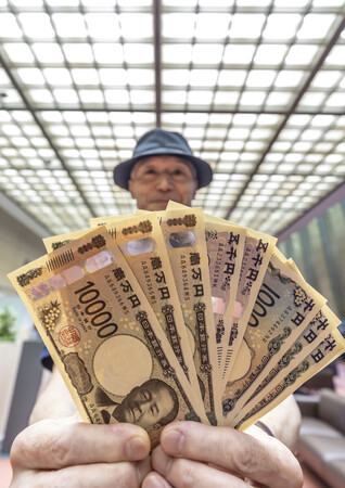 新紙幣を掲げる人=2024年7月3日、東京都千代田区