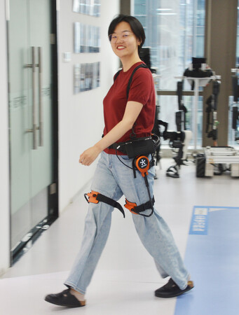 程天科技の登山支援ロボットを装着して歩く女性=6月24日、中国浙江省杭州市