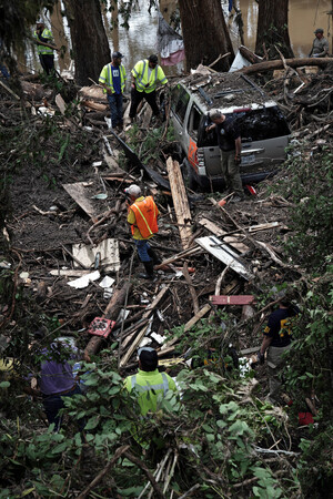 7日、米南部テキサス州で、行方不明者を捜索する人々(EPA時事)