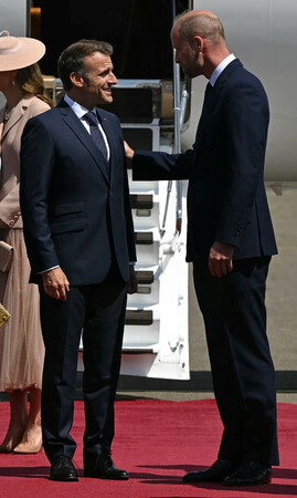 8日、ロンドン近郊のノースホルト空軍基地に到着し、ウィリアム英皇太子(右)の出迎えを受けるフランスのマクロン大統領(ロイター時事)