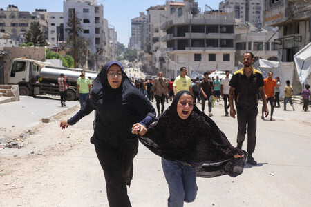 8日、パレスチナ自治区のガザ市で、イスラエルの攻撃から逃げようとする人々(AFP時事)