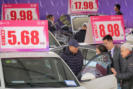 比亜迪（ＢＹＤ）の電気自動車（ＥＶ）を見る自動車ショーの来場者＝４月１０日、中国山東省煙台（ＡＦＰ時事）