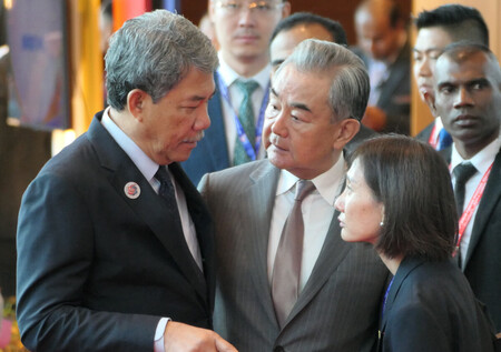 東南アジア諸国連合（ＡＳＥＡＮ）関連会議に出席後、マレーシアのモハマド外相（左）と話す中国の王毅共産党政治局員兼外相（中央）＝１０日、クアラルンプール
