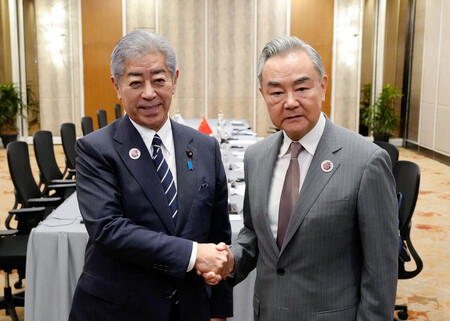 握手する岩屋毅外相（左）と中国の王毅共産党政治局員兼外相＝１０日、クアラルンプール（外務省提供）
