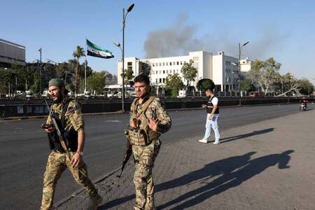 16日、イスラエル軍の攻撃を受け、ダマスカスの軍施設を警備するシリア治安部隊(AFP時事)