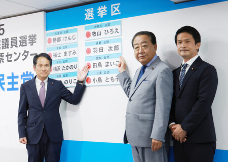 当選確実となった候補者名の前で、撮影に応じる立憲民主党の野田佳彦代表(右から2人目)ら=20日午後、東京都千代田区