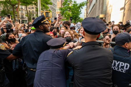 米コロンビア大の図書館前に集まった学生らともみ合う警官隊=5月7日、ニューヨーク(AFP時事)