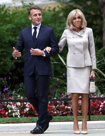 フランスのマクロン大統領(左)とブリジッド夫人=9日、ロンドン(EPA時事)