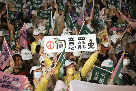 台湾立法委員（国会議員）のリコール推進団体が開いた集会で「罷免に同意」と書かれたプラカードを掲げる参加者＝２４日、台北市