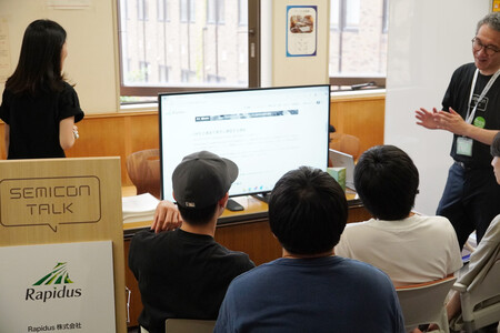 半導体企業が合同で開催したイベントで、ラピダスの担当者の説明を聞く北海道大の学生ら＝２５日午後、札幌市