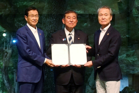経団連の夏季フォーラムで、石破茂首相（中央）に総括文書を手渡す筒井義信会長（右）＝２５日午後、長野県軽井沢町