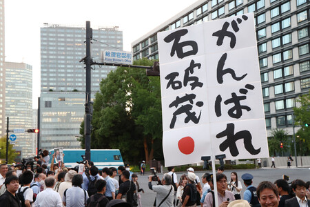 首相官邸前で「がんばれ石破茂」と書かれた紙を掲げる人たち＝２５日午後、東京都千代田区