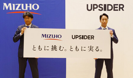 共同記者会見で撮影に応じるみずほフィナンシャルグループ（ＦＧ）の木原正裕社長（左）とＵＰＳＩＤＥＲホールディングスの宮城徹代表取締役＝２９日午前、東京都千代田区