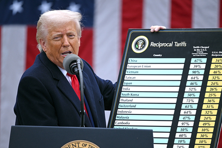 パネルを手に、関税措置について発表するトランプ米大統領＝４月２日、ワシントン（ＡＦＰ時事）