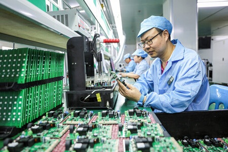 電気自動車（ＥＶ）用充電ステーションの製造ラインで働く従業員＝７月９日、中国江西省（ＡＦＰ時事）