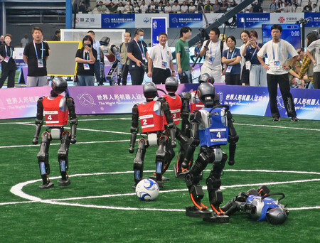 「世界人型ロボット運動会」のサッカーの試合。人型ロボットがボールを奪い合った＝１５日、中国・北京市