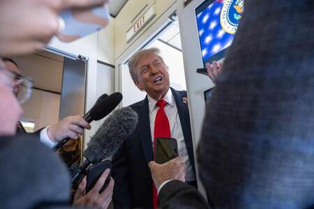 15日、専用機内で取材に応じるトランプ米大統領(AFP時事)