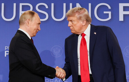 15日、米アラスカ州アンカレジで行われた記者会見で握手を交わすロシアのプーチン大統領(左)とトランプ米大統領(ロイター時事)