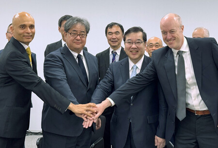理化学研究所が開発を進めるスパコン「富岳」後継機の共同開発に参加することが決まり、五神真理事長(前列右から2人目)らと握手する米半導体大手エヌビディアのイアン・バック副社長(同右端)=22日午前、東京都中央区