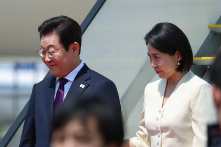 東京・羽田空港に到着した韓国の李在明大統領(左)と金恵景夫人=23日午前